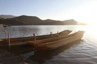 湖畔小船静泊于晨光中