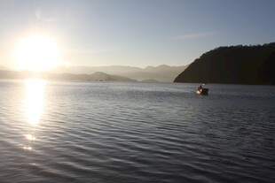 日出湖面小船静谧景象