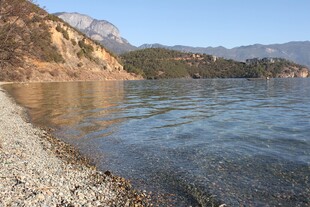 宁静湖畔的沙石与远山