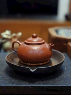 古朴紫砂壶置于盘上