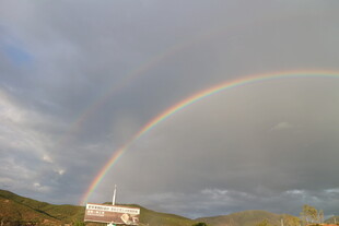 山间彩虹下的美丽建筑