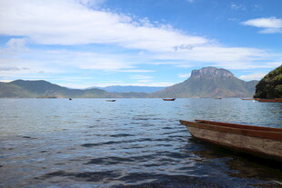 湖畔小船与远处山峦美景