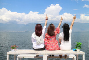 三女孩海边长椅惬意赏景