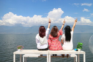 三女生坐露台眺望美丽湖景