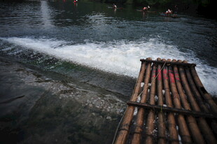 竹筏漂流于湍急溪流间
