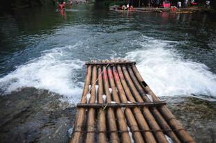竹筏漂流于湍急水流中