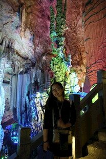 女子身处梦幻溶洞景观中