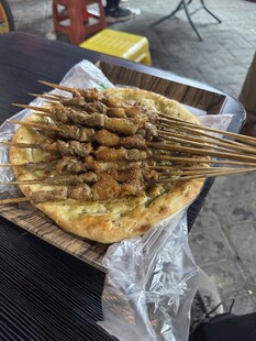 美味烤串摆放在竹制托盘上
