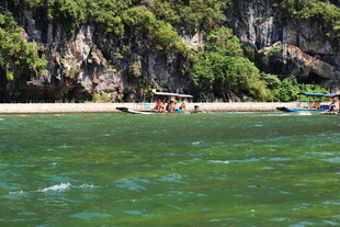 海边峭壁下的多彩船只