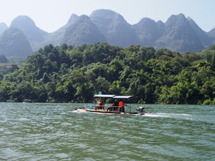 江上小船穿行于青山间