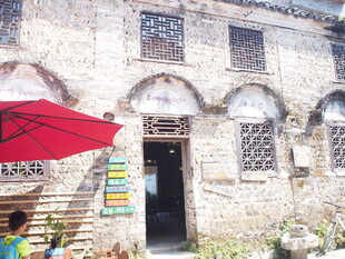 古旧建筑门前的红色遮阳伞