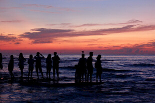 夕阳下海边的人群剪影
