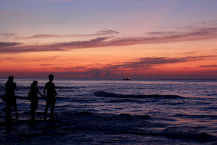 海边日落时的三人身影