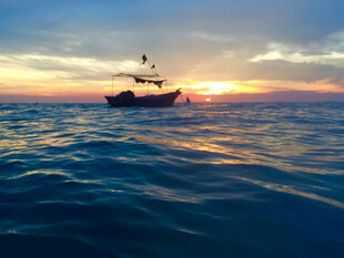 海上落日中的孤独渔船