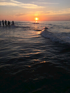 海边日落时的踏浪人群