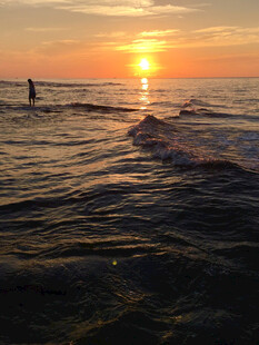 海边日落时的冲浪者