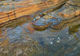溪边生锈机械零件特写