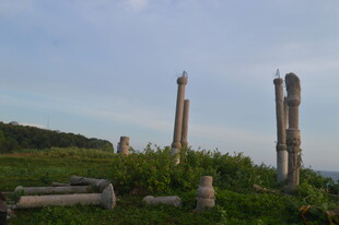 古老石柱屹立于绿意之中