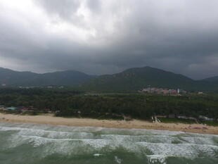 海边乌云下的山峦与沙滩