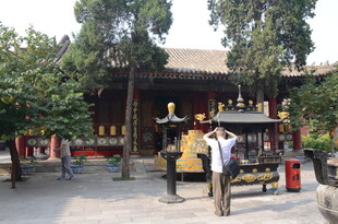 古寺前的游客与金色雕塑