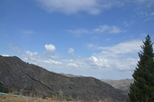 山间蓝天绿树风景图