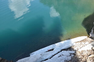 湖畔覆雪岩石与清透湖水