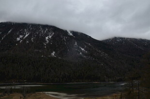 阴云下的雪山与河谷景观