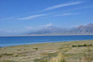 湖畔草原与远山蓝天美景