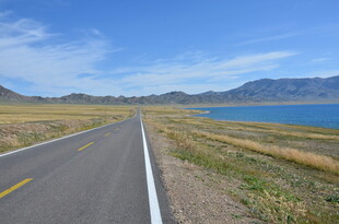 公路伸向蓝色湖泊美景