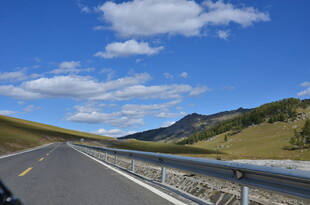 蜿蜒公路穿行于青山蓝天