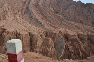 沙漠中的红白界碑与山峦