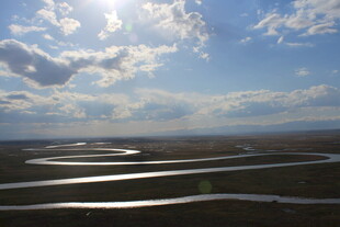草原蜿蜒河流与蓝天白云