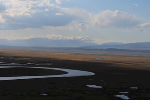 草原蜿蜒河流与远山风景