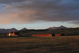 草原暮色中的屋舍与远山