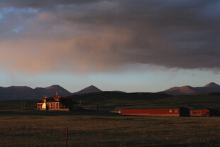草原暮色中的屋舍与远山
