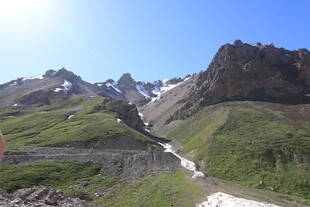 山间溪流穿草地雪山景