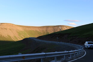 山间公路上行驶的白色车辆