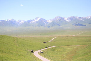 草原公路上的车辆与远山