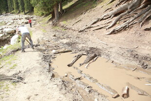 男子骑行于泥泞山间小道