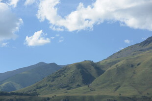 蓝天白云下的翠绿山峦