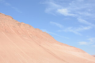 蓝天映衬下的红色山坡