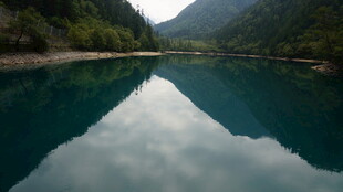青山环抱的静谧碧绿湖水