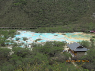 山间彩池旁的古朴小屋