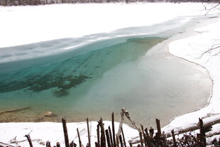 冬日雪覆岸边的清澈湖水