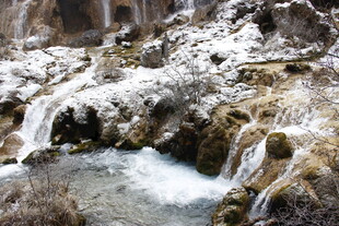 雪覆山间溪流瀑布美景