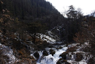 山间冰雪覆盖的潺潺溪流