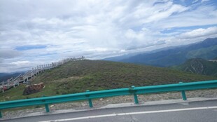 公路旁的青山与蓝天白云