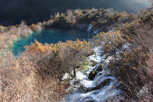 雪覆山林间的幽蓝湖泊