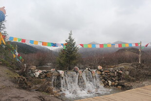 山间五彩经幡下的小瀑布