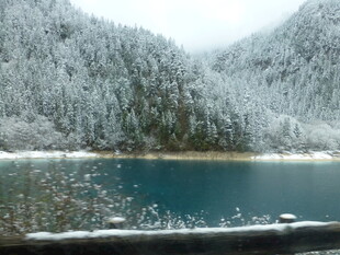 雪覆山峦下的幽蓝湖泊